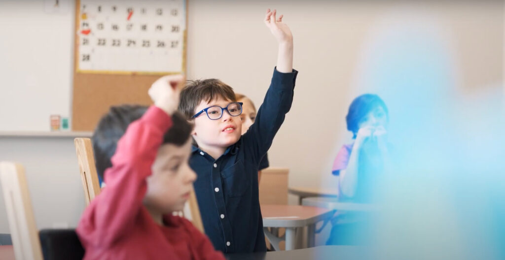 Enfants qui lève la main en classe